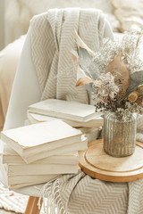 Home interior with books and dried flowers.