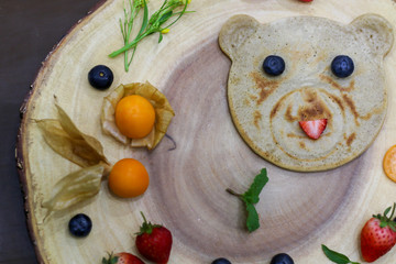 Organic bear pancake topping with honey, berry and fruit healthy food.