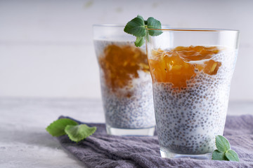 Homemade chia pudding with orange jam and mint in a glass