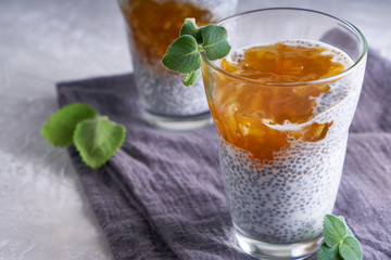 Homemade chia pudding with orange jam and mint in a glass