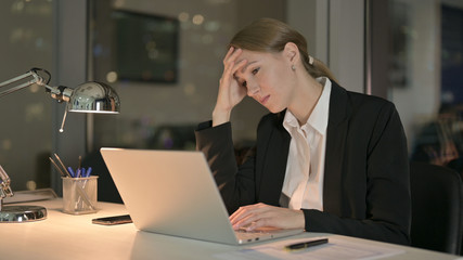 The Tired Businesswoman having Headache on Office Desk at Night