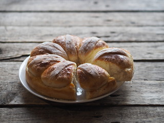 Festive Easter, Christmas or everyday bread rolls on a wooden rustic ancient table.Homemade cake. Side view.