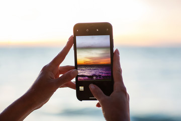 Beautiful woman by the ocean at sunset