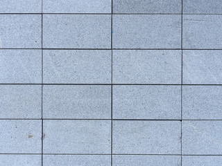Wall of gray granite tiles, background.