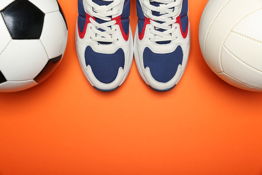 Soccer Ball, Volleyball Bal And Sport Shoes On Orange Background Top View With Copy Space. Physical Education Lessons At School