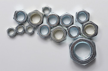 New chrome screw-nut of different sizes on a white background. Concept.