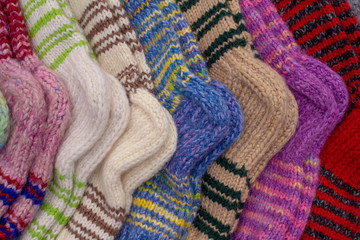 Fototapeta na wymiar There are multi-colored knitted warm wool socks. warm winter clothing handmade.