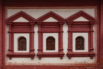 Fototapeta premium Fragment of a wall of an old church with three windows framed by stucco molding