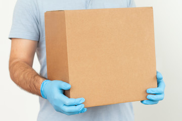 Delivery man holding cardboard boxes in rubber gloves / copy space. Fast and free Delivery transport . Online shopping and Express delivery 