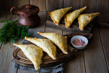 Ruddy pies with meat and rice on a beautiful wooden Board