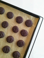 Ready-made chocolate cookies on a baking tray. The cooking process is step by step.