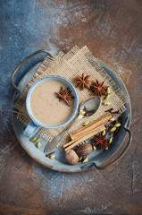 Fototapeta na wymiar Indian masala chai tea. Spiced tea with milk on dark rusty background.