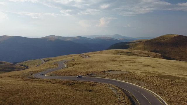 Aerial Flying Over Winding Road In Rolling Mountains