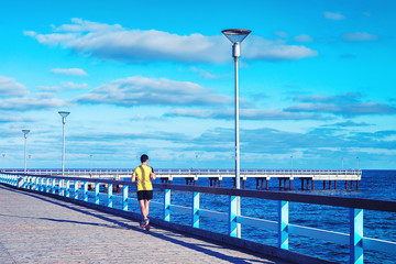 Obraz premium Man running Sea Bridge Baltic sea in Palanga resort