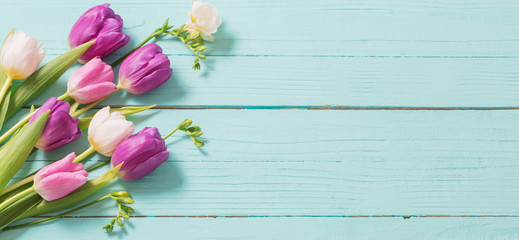 Naklejka na ściany i meble spring flowers on blue mint wooden background