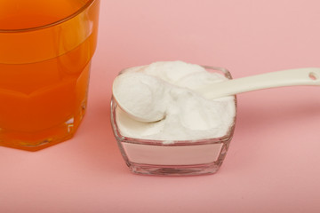 Collagen powder on pink background. Extra protein intake. Natural beauty and health supplement for skin, bones, joints and gut. Plant or fish based. Flatlay, top view. Copy space for your text.