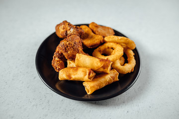 Fried snack plate, Onion rings, spring rolls and chicken nuggets 