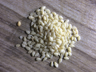 Close up of organic raw white sesame seeds on wooden background. .Macro shot.