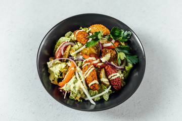 Falafel salads on dark plate close up