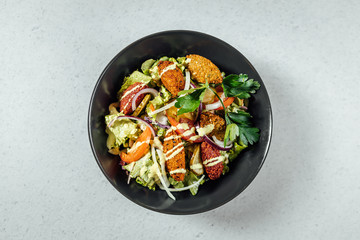 Falafel salads on dark plate close up