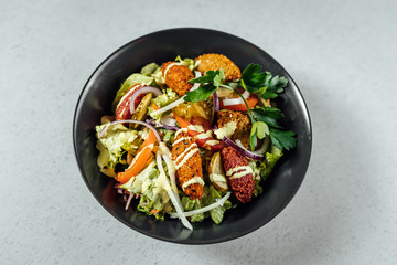 Falafel salads on dark plate close up