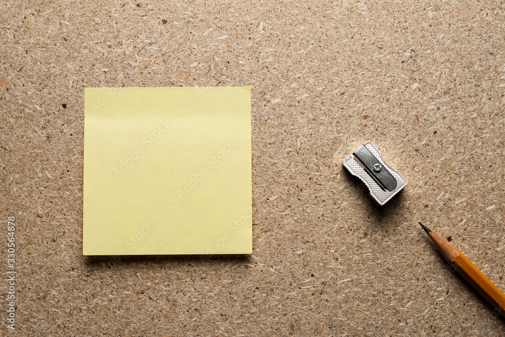 Wall mural pencil, sharpener and paper sticker on a chipboard table. view from above