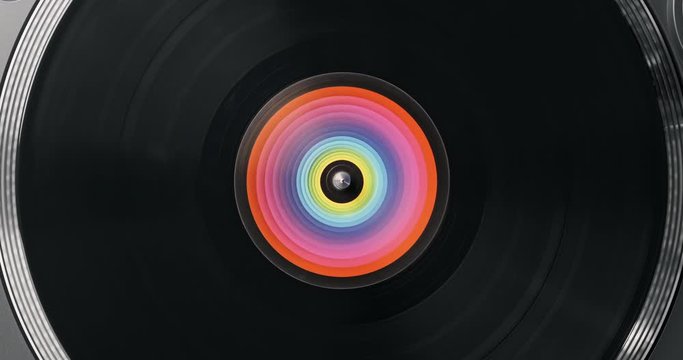 Black vinyl record DJ player. Black vinyl background with color spectrum label in center. Rotating plate close-up on turntable. Loop. Macro Top view. Popular styles of disco from 60s, 70s, 80s, 90s
