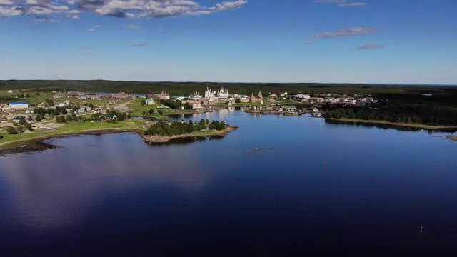 Smooth cinematic approaching-flight to the Solovetsky monastery from the White Sea (Bay of Prosperity) on the sunny day. Solovetsky monastery is an old (1420) ROC monastery.