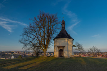 Fototapeta na wymiar Chapel on hill over Trebic town in Moravia region in sunset evening