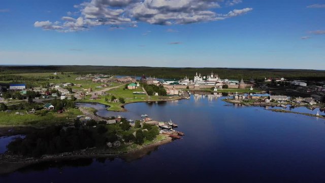 Smooth cinematic approaching-flight to the Solovetsky monastery from the White Sea (Bay of Prosperity) on the sunny day. Solovetsky monastery is an old (1420) ROC monastery.