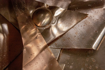 Sheets of copper on the table. Scraps of copper sheets of different sizes.