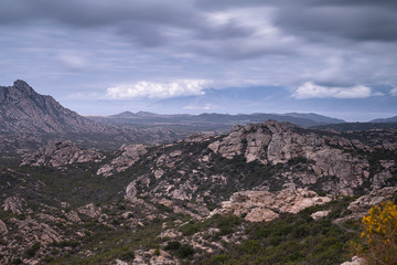 Desert des Agriates - rugged scenary, garrigue vegetation. Mediterranean Sea in the distance and an outline of Cap Corse