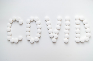 Лекарства таблетки на белом фоне белые  слово ковид