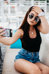 Beautiful young woman doing selfie on the beach