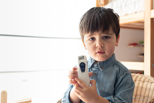 Little boy using a digital thermometer