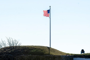 American flag on bluff snapping stiff in breeze