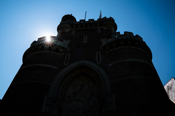 Fototapeta na wymiar Silhouette of Front Exterior part of the Gaasbeek Castle facade in the municipality of Lennik, Belgium with blue sky and sun flare