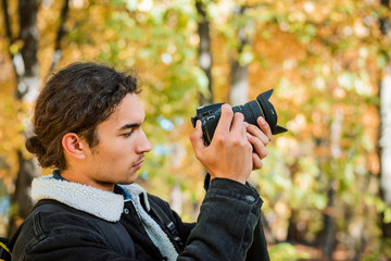 Taking pictures outdoor. Beginner photographer taking photos of nature in the park