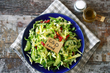 Selective focus. A note with the words cbd food in a plate with vegetable salad. Salad with the...