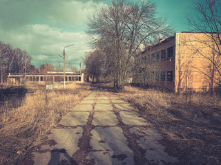 An old dilapidated house on the street of an abandoned industrial city