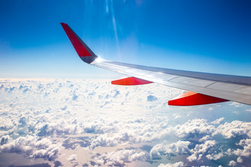 Fototapeta premium Plane wing window view sea clouds.