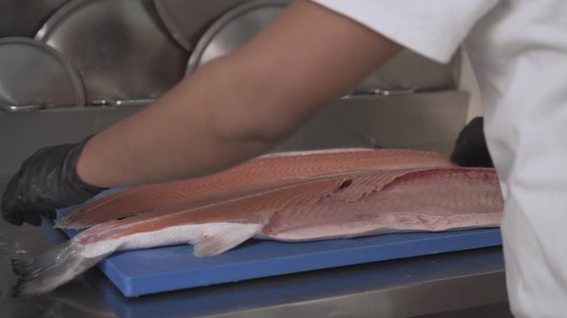 Close-Up Shot of a Chef Filleting and Flipping over a Fresh Salmon Fish