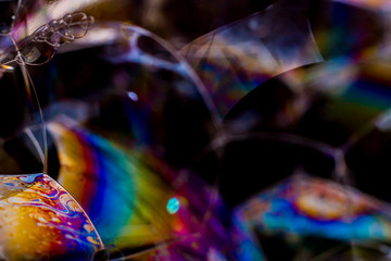Macro photography of various soap bubbles creating different geometric shapes with striking colors, selective focus