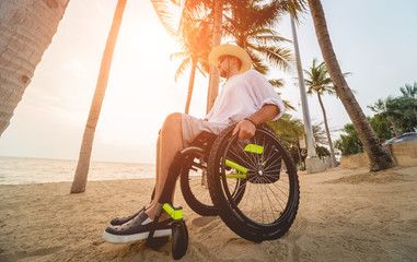 Disabled man in a wheelchair on the beach.