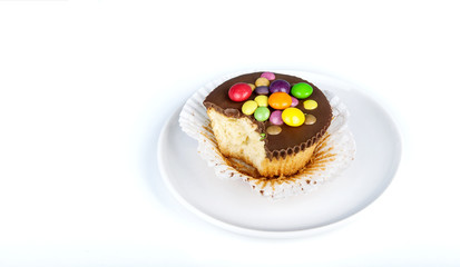 bitten capcake decorated with colorful dragees on the plates