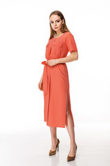 Attractive girl in a dress against a white wall