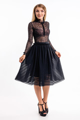 Fototapeta premium Attractive girl in a dress against a white wall