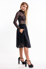 Attractive girl in a dress against a white wall