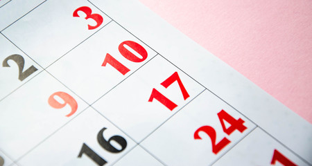 Macro calendar from different angles on a yellow and pink background. Black and red numbers on the calendar.  Copy Space