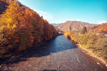 Beautiful nature landscape. Mountain river with rocky hills at sunset in autumn